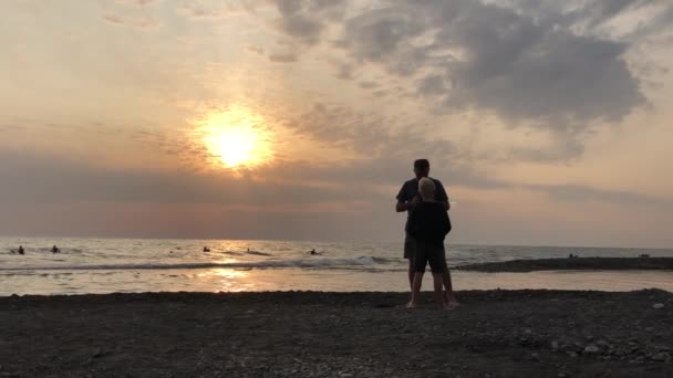 Táta a syn si povídají při západu slunce u moře — Stock video