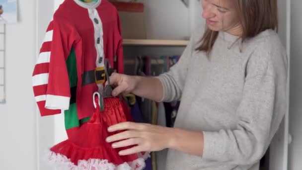 Mamá recoge un disfraz para Año Nuevo y Navidad para una hija pequeña. — Vídeos de Stock