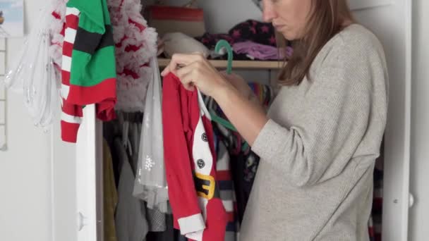 Eine Frau wedelt mit Silvestersachen im Schrank einer kleinen Tochter. — Stockvideo