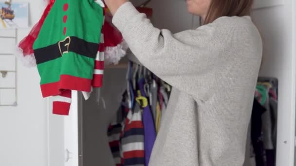 Hemmafru hänger barn nyår och juldräkter i garderoben av en liten dotter — Stockvideo