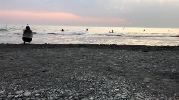 Kobieta bierze na telefon piękny zachód słońca w morzu i mewy krążące nad wodą — Wideo stockowe