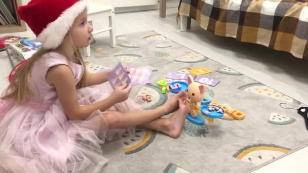 Elegantní malá dívka rozbije hračky váhy pro studium matematiky. — Stock video