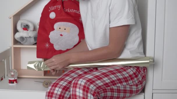 Una mujer que envuelve un regalo para el nuevo año y la Navidad en papel marrón — Vídeos de Stock