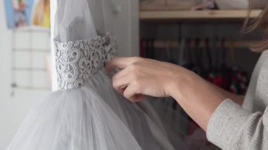 Annem küçük bir kız için güzel kıvrımlı bir elbise hazırlar.