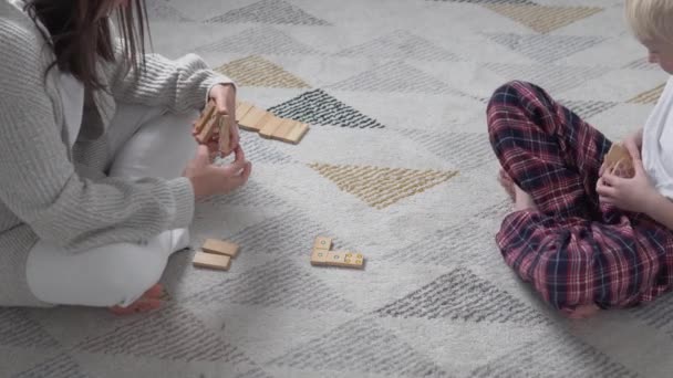Mutter und Sohn spielen zu Hause in hölzernen Dominosteinen während carantite covid-19 — Stockvideo