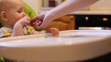 Anne önce bebeği bebek koltuğunda besliyor..