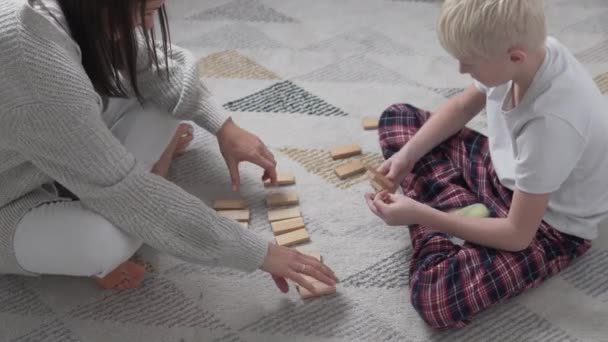 Pojke och mamma spelar domino hemma under lockdown covid-19 — Stockvideo