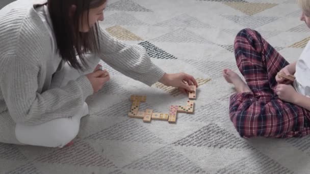 Mutter und Sohn spielen im Winter zu Hause auf dem Fußboden in Holz-Dominosteinen — Stockvideo