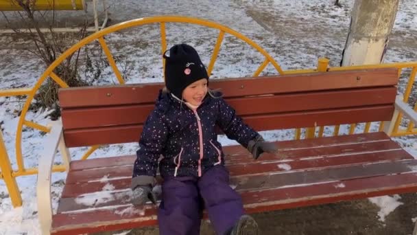 Malá holčička chodí v zimě po ulici. — Stock video