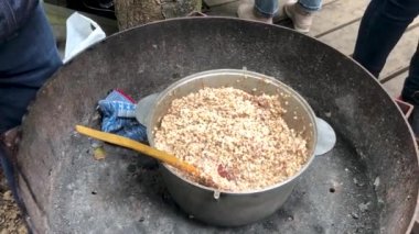 Bir adam, Anavatan 'ın Koruyucuları Günü kutlamaları sırasında askerlere yulaf lapası veriyor.