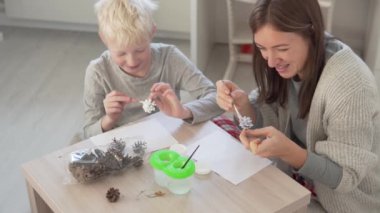 Anne ve oğlu Noel ağacında Noel oyuncakları yapıyor.
