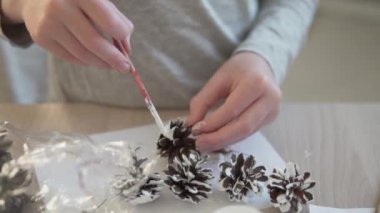 Yakından bakınca, çocuk Noel ağacını süslemek için ladin renkli beyaz bir boya çiziyor.