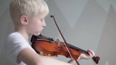 Güzel sarışın bir çocuk müzik okulunda keman çalmayı öğreniyor.