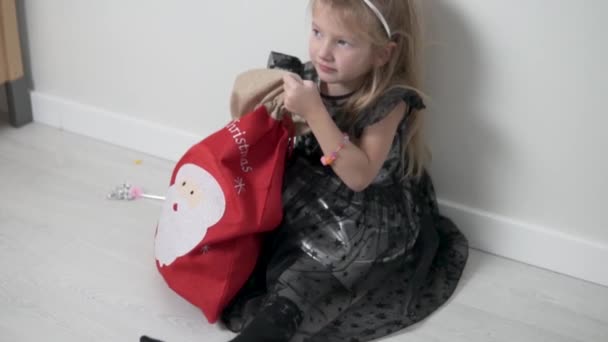 Una hermosa niña saca de una bolsa de regalos para Navidad un gran paquete de máscaras desechables médicas — Vídeos de Stock