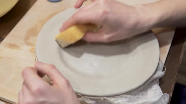 La mujer hace un plato de arcilla, la etapa de alinear la forma con un paño húmedo, la preparación para la aplicación de la pintura — Vídeo de stock