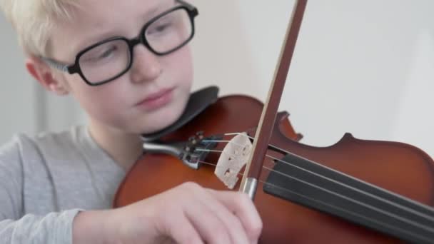 Um menino bonito com óculos toca violino — Vídeo de Stock