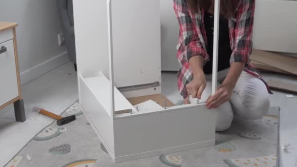 Женщина собирает стол из деталей дома. — стоковое видео