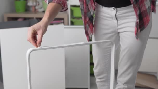 La femme colle des autocollants doux sur les jambes de la table des enfants, quoi qu'il gratte les sols — Video