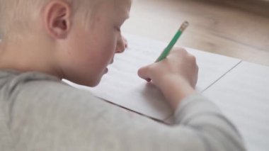 Yakın plan, çocuk not defterine notlar yazıyor.