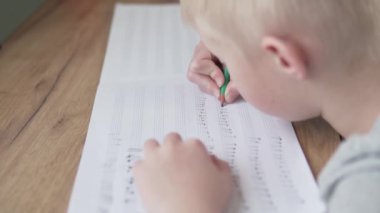 Çocuk not defterine not yazmayı öğreniyor.