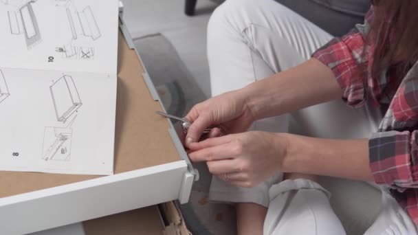 The woman collects the drawer for the table — Stock Video