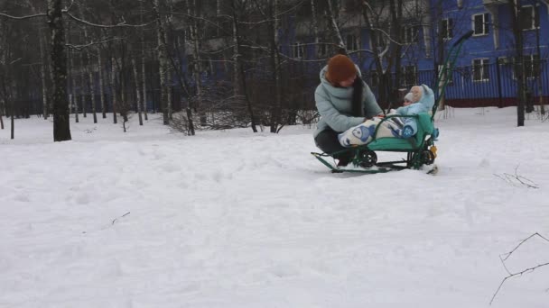 Mãe em um passeio com uma criança pequena em um trenó no inverno na Rússia — Vídeo de Stock