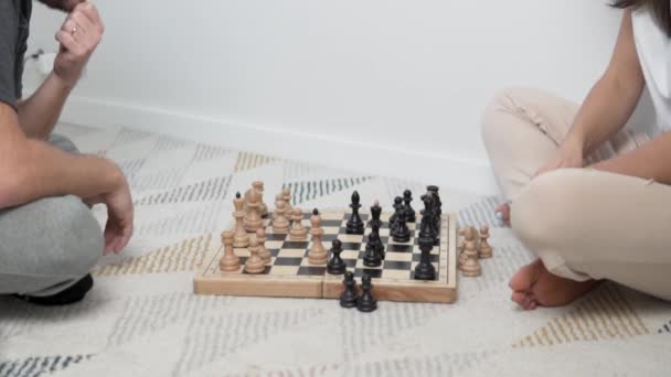 Ένας άντρας και μια γυναίκα παίζουν σκάκι στο σπίτι. — Αρχείο Βίντεο
