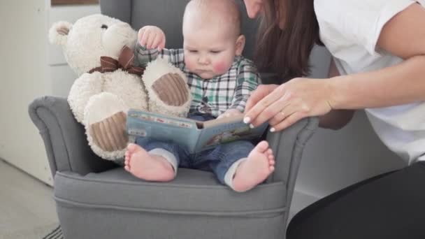 Máma čte knížku malému dítěti doma. — Stock video
