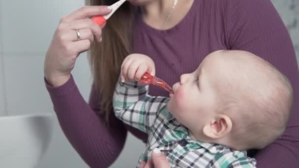 Máma učí čistit zuby malého dítěte doma v koupelně — Stock video