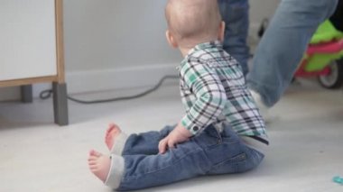 Anaokulunda yerde sürünen küçük bir çocuk.