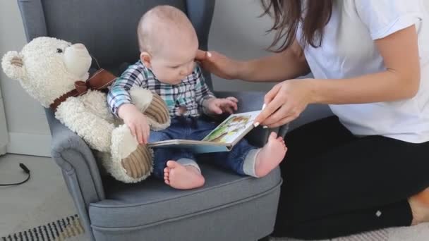 Mama liest einem kleinen Kind zu Hause ein Bilderbuch vor — Stockvideo