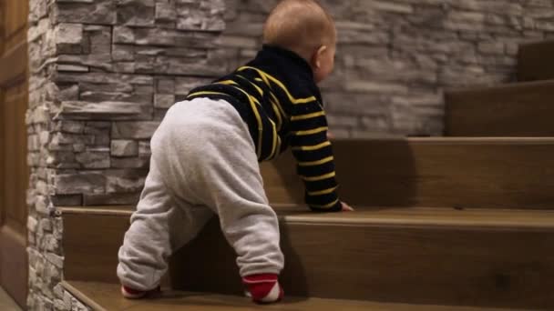 Un niño pequeño sube por las escaleras de la casa — Vídeos de Stock
