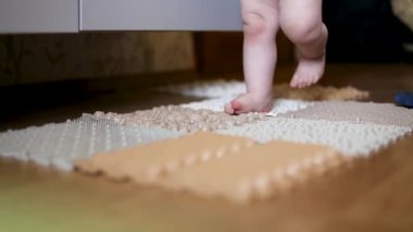Küçük çocukların bacakları masaj minderinde yürür