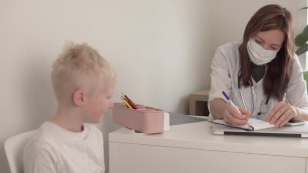 Güzel bir kadın. Doktor, genç bir çocukla hastanede oturuyor. — Stok video