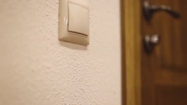 Küçük bir çocuk, düğmeye ulaşmaya çalışır ve odadaki ışığı söndürmeye çalışır. Küçük bir çocuk, düğmeye ulaşmaya çalışır ve odadaki ışığı söndürür.