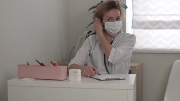 Жінка-лікар піднімається зі столу і залишає офіс — стокове відео