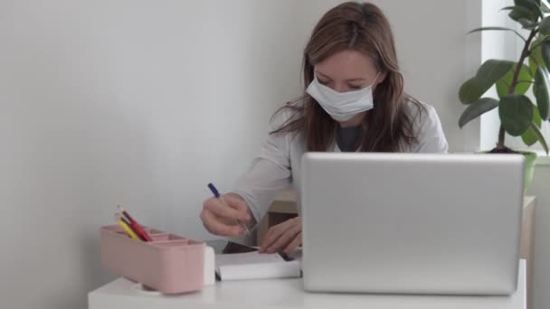 A tired woman doctor in a medical mask on her face falls asleep in the office at the computer — Stock Video