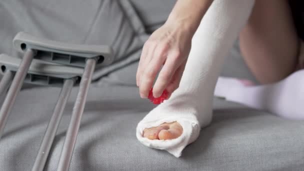 Egy nő felmelegíti a zsibbadt lábujjakat a vakolatban — Stock videók