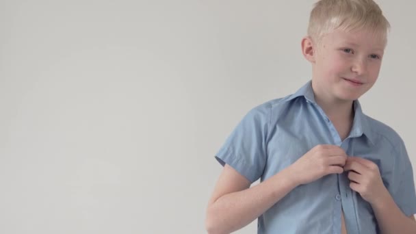 Красивый мальчик блондин пуговицы на школьной рубашке, — стоковое видео