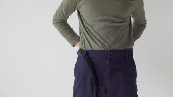 L'adolescente inserisce una cintura nei pantaloni e la fissa — Video Stock