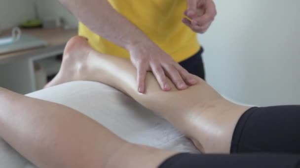 Professionele masseur massages een vrouw benen — Stockvideo
