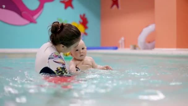 엄마는 수영장에서 아기와 수영하는 법을 가르친다 — 비디오