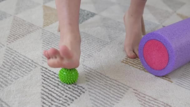 Uma mulher rola uma bola de massagem nos pés para relaxar a perna após a fisioterapia — Vídeo de Stock