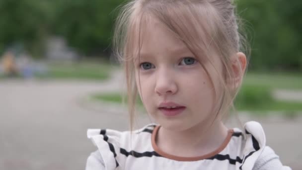 Gros plan mignonne petite fille qui parle dans la rue — Video