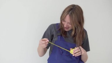 Takım elbiseli komik bir kadın bir santimetre rulete bakıyor.