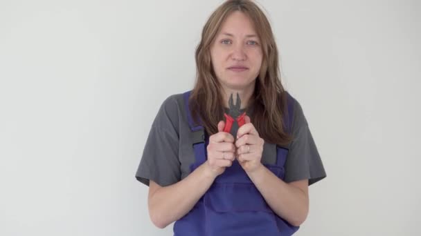 Η Αστεία Γυναίκα βγάζει τανάλια από την τσέπη της εργαζόμενης στολής της. — Αρχείο Βίντεο