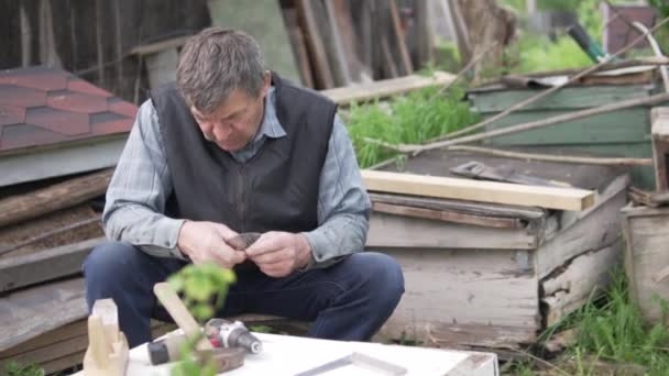 Starszy mężczyzna robi pudełko latem w domku letniskowym. — Wideo stockowe