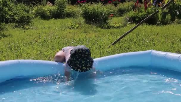 Un bambino spruzza acqua in una piscina per bambini in estate nel caldo in Russia — Video Stock