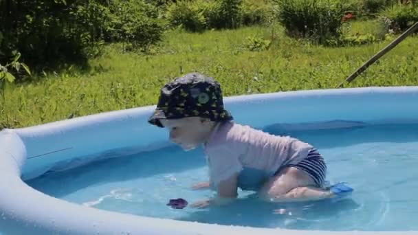 Zabawny dzieciak schłodzony w basenie w wodzie latem w domku letniskowym — Wideo stockowe