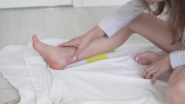 Žena se podívá na jizvu na noze a ráno začne protahovat operovanou nohu. — Stock video